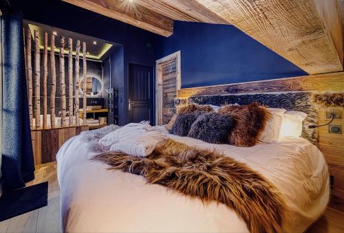 sypialnia z dużym białym łóżkiem z futrzanymi poduszkami w obiekcie Appartement style chalet 5* vue Mont-Blanc - Arc 1950 w mieście Arc 1950