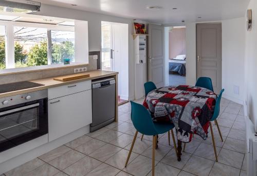 une cuisine avec une table et des chaises dans une cuisine dans l'établissement Pamiers gare - 2 Appartements à louer ou Chambre parentale indépendante, à Pamiers