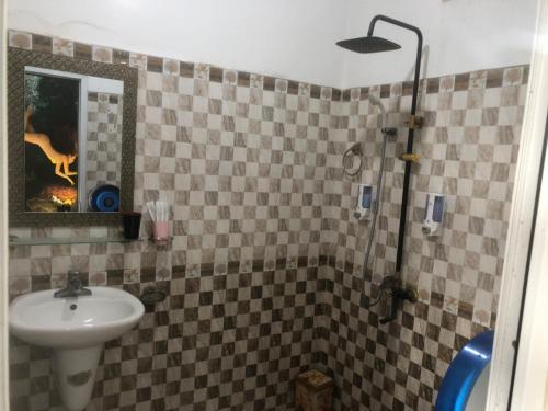 uma casa de banho com um lavatório e um chuveiro com um espelho. em Hotel Nam Sơn em Lương Kê