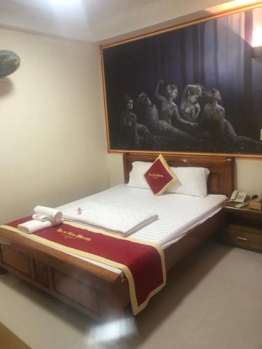 a bedroom with a bed with a painting on the wall at Hotel Nam Sơn in Lương Kê