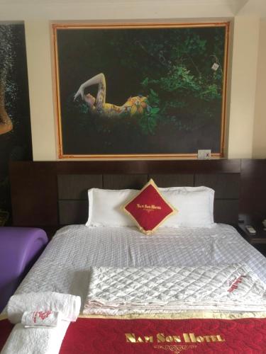 a bedroom with a large painting above a bed at Hotel Nam Sơn in Lương Kê