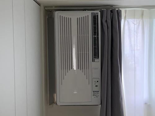 a microwave oven in a room with a window at O2 capsule house OTARU in Otaru