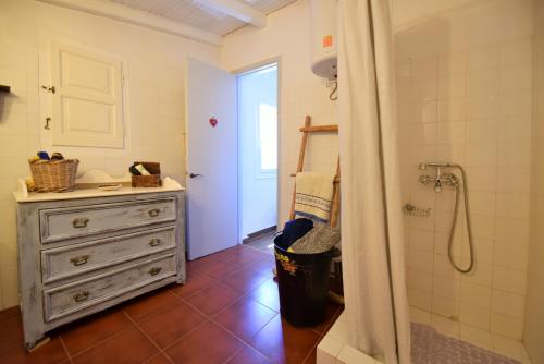 uma casa de banho com uma cómoda, um lavatório e um chuveiro em Nelly's Coastal Family House em Hydra