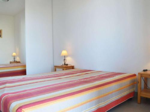 Ce lit se trouve dans un dortoir doté de 2 tables et de 2 lampes. dans l'établissement Appartement 3 pièces avec terrasse, parking sécurisé, proche mer - 6 couchages à Narbonne Plage - FR-1-229B-4, à Narbonne