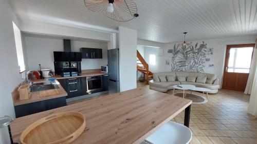 cocina y sala de estar con mesa de madera en Chez Marie, en Albaret-Sainte-Marie