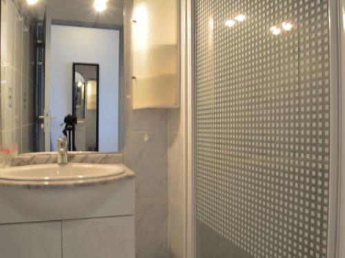 une salle de bain avec un lavabo et une douche avec un miroir dans l'établissement Appartement T2 bord de mer avec piscine, parking, Saint-Cyprien Plage - FR-1-225D-13, à Saint Cyprien Plage