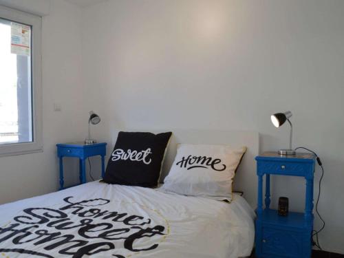 - une chambre avec un lit et 2 tables de nuit bleues dans l'établissement Appartement rénové, climatisé à 200m de la plage avec balcon et parking privé - FR-1-229D-12, à Fleury