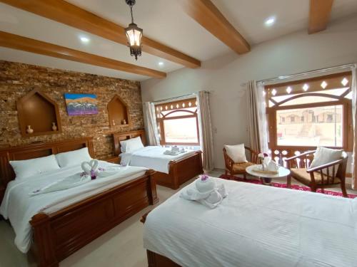 Durrat Nizwa Hotel في نزوى‎: غرفة نوم بسريرين وطاولة وكراسي