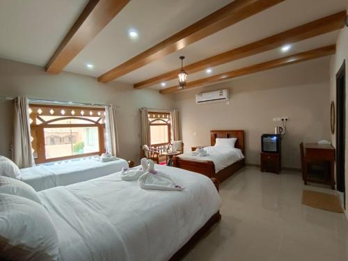 a hotel room with two beds and a television at Durrat Nizwa Inn in Nizwa