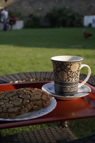 a cup of coffee and cookies on a table at Farsal Villa in Srinagar