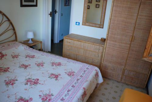 a bedroom with a bed and a dresser and a mirror at Giannella Apartment in Orbetello