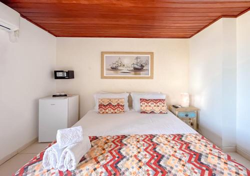 a bedroom with a bed with a wooden ceiling at Pousada do Albatroz in Cabo Frio
