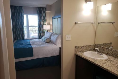 La salle de bains est pourvue d'un lit avec un lavabo et un miroir. dans l'établissement VACATION VILLAGE PARKWAY - KISSIMMEE,FL 34747, à Orlando