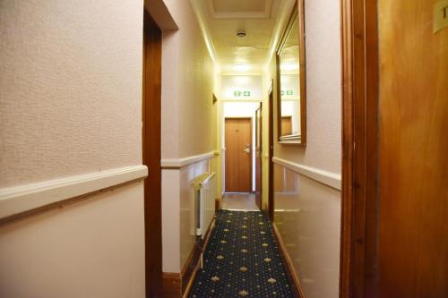a hallway with a long aisle with a door and a hallwayngthngthngthngth at Crystal Hotel & Savour in Cambridge