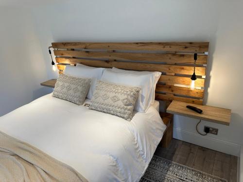Tangmere的住宿－Two miles from Goodwood，卧室配有白色的床和木制床头板