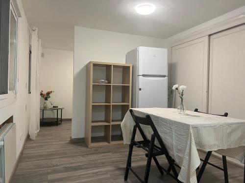 a white kitchen with a table and a refrigerator at Marbella别墅独立房带泳池 in Marbella