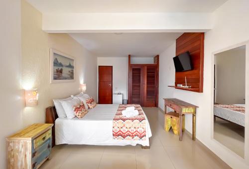 a bedroom with a bed and a television in it at Pousada do Albatroz in Cabo Frio