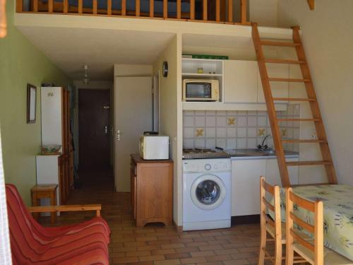 une petite cuisine avec un escalier et un lave-linge. dans l'établissement Charmant T2 Mezzanine avec Piscine à Port Cogolin – 6 Couchages, Parking Privatif, Proche Plages - FR-1-226B-39, à Cogolin