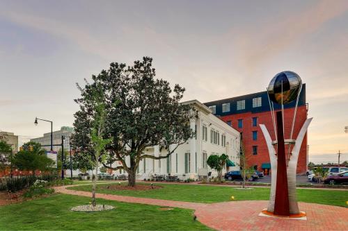 a sculpture in a park in front of a building at Trilogy Hotel Montgomery, Autograph Collection in Montgomery
