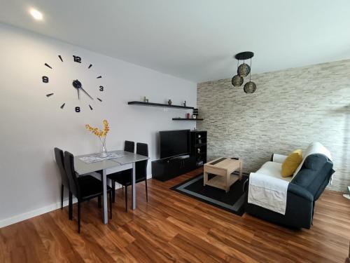 uma sala de estar com uma mesa e um relógio na parede em Piso recién reformado en Gascona em Oviedo