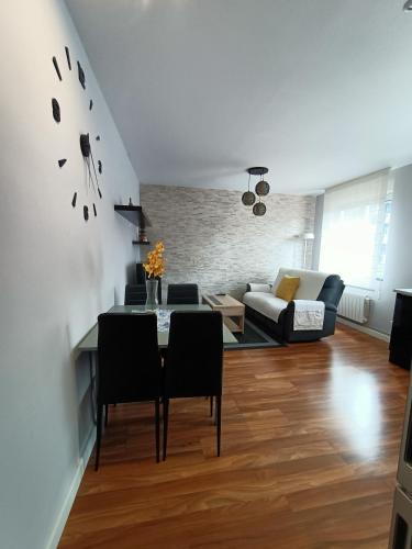 a living room with a table and a couch at Piso recién reformado en Gascona in Oviedo