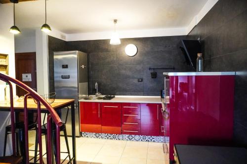 cocina con armarios rojos y nevera roja en Comfortable Duplex with Garage and Working space, en Puertito de Güímar