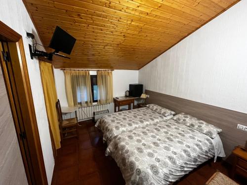 1 dormitorio con 1 cama y TV de pantalla plana en La Antigua Vaquería, en Cuenca