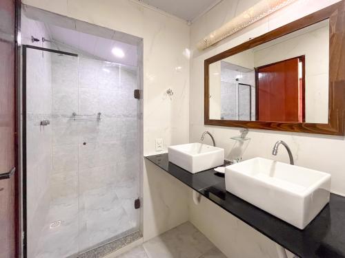 a bathroom with two sinks and a shower at Pousada do Albatroz in Cabo Frio