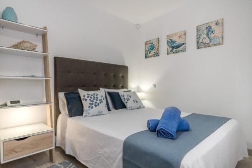 una camera da letto con un letto con asciugamani blu di ANIDRAS Rooms a Sardina