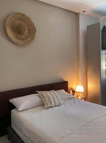 ein Schlafzimmer mit einem Bett mit einem Hut an der Wand in der Unterkunft Cozy vintage styl bedroom family only in Tangier
