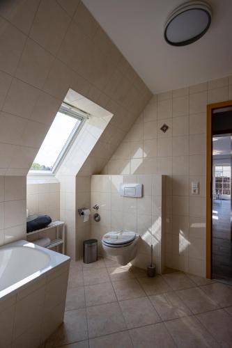 a bathroom with a tub and a toilet and a sink at Ferienwohnung Gartenstadt Seilerberg in Freiberg
