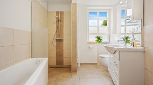 a bathroom with a tub and a sink and a toilet at Hotel Deichinsel in Wangerland