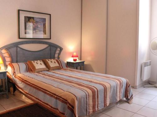 een slaapkamer met een groot bed en een gestreepte deken bij Maison Fleury-Saint-Pierre-la-Mer, 2 pièces, 6 personnes - FR-1-229D-82 in Fleury