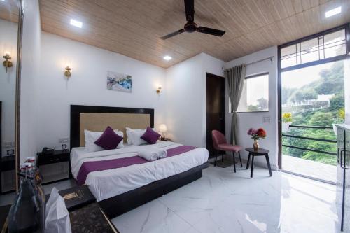 a bedroom with a large bed and a large window at PerfectStayz Mussoorie Hills in Mussoorie