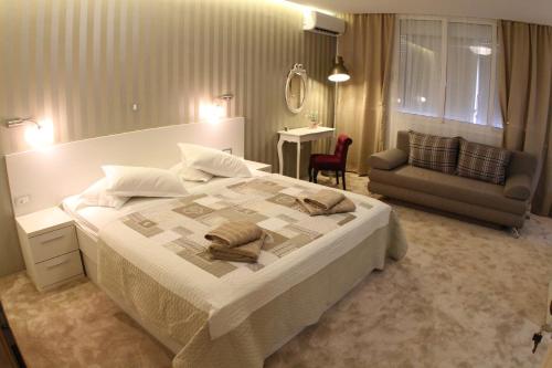 a bedroom with a large white bed and a couch at Studio Apartments Mirakul in Split