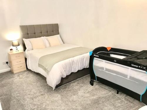 a small bedroom with a bed with a suitcase at Dolphin Retreat close to Beaches and Harbour in Poole