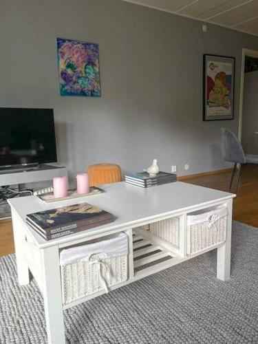 a white desk in a living room with a tv at Koselig leilighet med et skritt unna skibakken! in Kongsberg