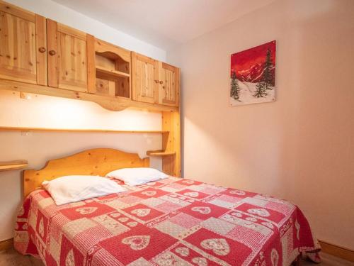 een slaapkamer met een bed met een rode en witte deken bij Appartement Valmorel, 3 pièces, 6 personnes - FR-1-291-834 in Valmorel