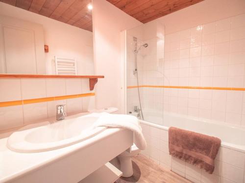 een witte badkamer met een wastafel en een bad bij Appartement Valmorel, 3 pièces, 6 personnes - FR-1-291-834 in Valmorel