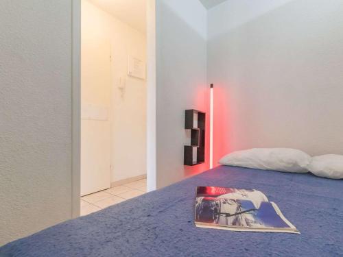 un livre assis sur un lit dans une pièce dans l'établissement Appartement 2 pièces, 4 pers. à Briançon - Proche pistes et centre, parking inclus - FR-1-330C-100, à Briançon