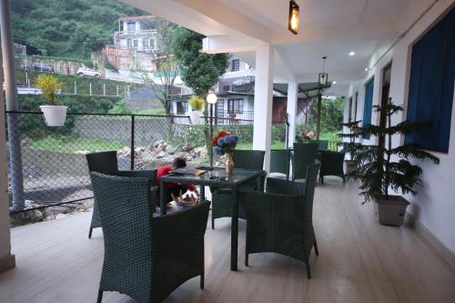a patio with a table and chairs with a view at PerfectStayz Mussoorie Hills in Mussoorie