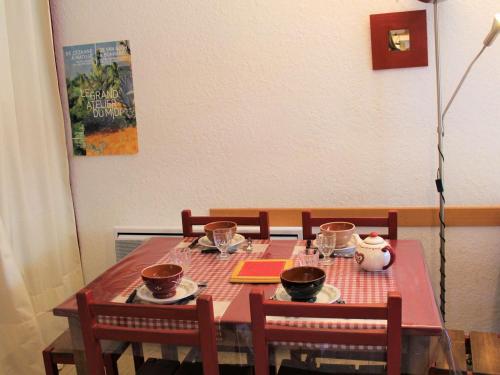 une table à manger avec deux chaises et un tissu de table rouge dans l'établissement Studio cabine & coin montagne avec balcon, 4 couchages, à 100m des pistes - Vars - FR-1-330B-122, à Vars