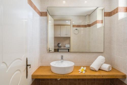 La salle de bains est pourvue d'un lavabo et d'un miroir. dans l'établissement Manousis ApartHotel, à Tsilivi