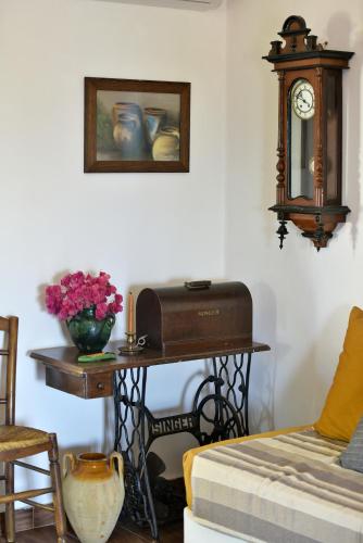 a room with a table with a sewing machine and a clock at Nelly's Coastal Family House in Hydra