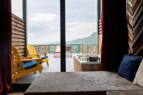 a bedroom with a bed and a balcony with a view at Mtserlebi Resort in K'vishkhet'i
