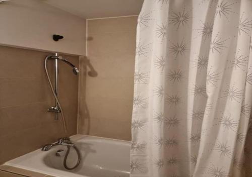 a bathroom with a shower curtain and a tub at Your Riverside Home in Woolwich