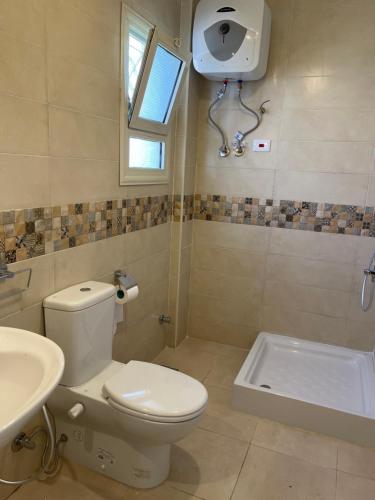 uma casa de banho com um WC, um lavatório e uma banheira em Stunning Beachfront Villa on North Coast Mediterranean em Dawwār Abū Maḩrūs