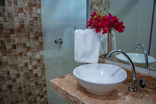 a bathroom with a sink and a vase of flowers at Pousada Ksa Zen Jeri in Jericoacoara