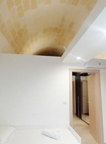 a room with a white bed and a ceiling at STRADONE 132 in Gravina in Puglia