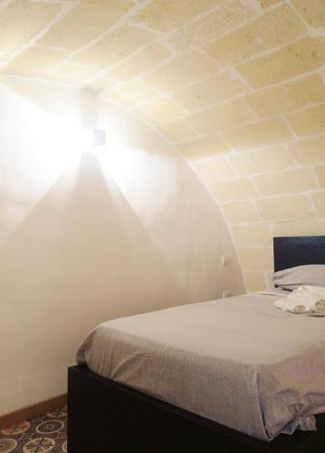 a bedroom with a bed with a light on the ceiling at STRADONE 132 in Gravina in Puglia